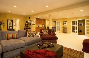 Cozy basement living area with a sofa, armchair, and decorative accents.