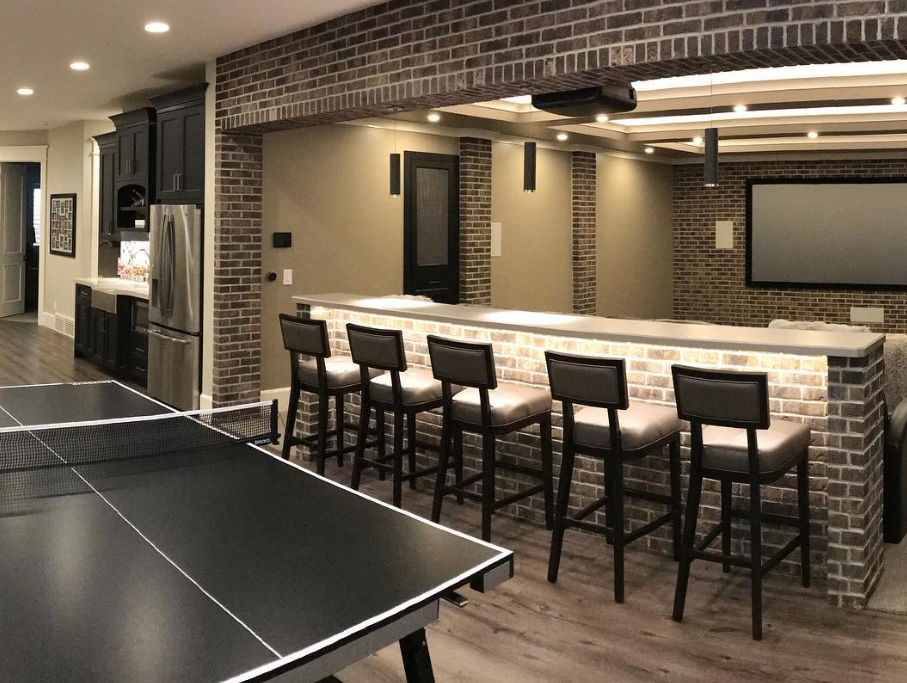 Modern basement bar and theater area with seating and ping pong table