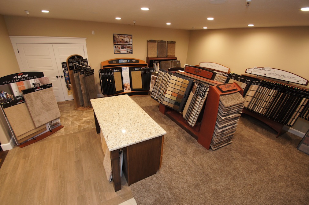 Wide view of a carpet showroom featuring various flooring samples and displays.