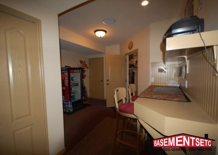 View of a remodeled laundry room and craft space with seating and appliances.