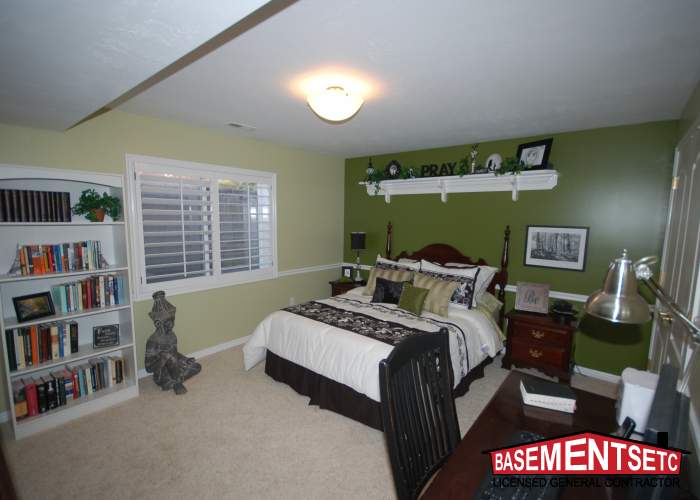 Cozy bedroom with green walls, a bookshelf, and decorative elements.