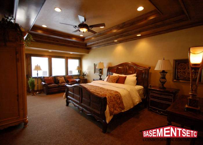 Cozy bedroom featuring a wooden bed, lamps, and a seating area.