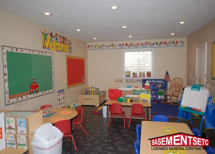 Brightly colored classroom with tables, chairs, and educational materials.
