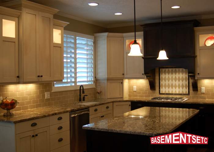 Modern kitchen with granite countertops, white cabinets, and pendant lighting.
