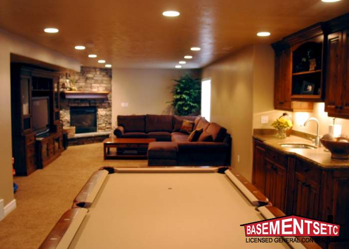 Cozy family room with a pool table, couch, and stone fireplace.
