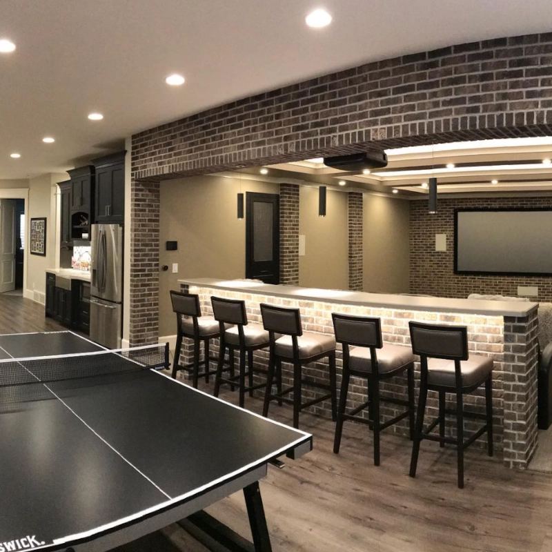 Modern basement with a bar, seating, and a ping pong table.
