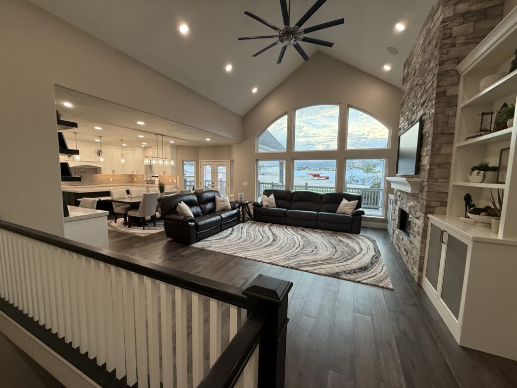 Spacious living room with large windows, modern furniture, and a cozy rug.