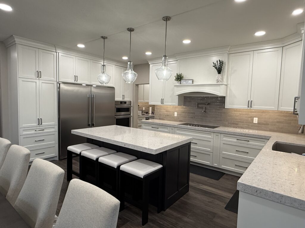 Modern kitchen with white cabinets, stainless steel appliances, and a large island.