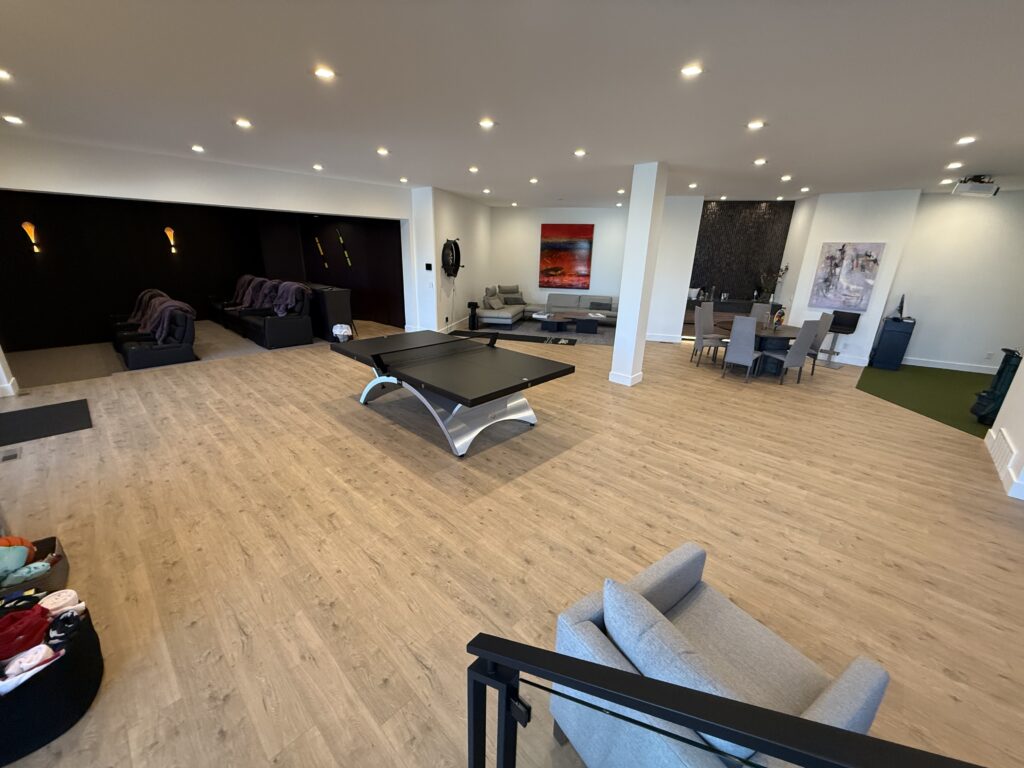 Spacious basement with a pool table, seating area, and dining space.