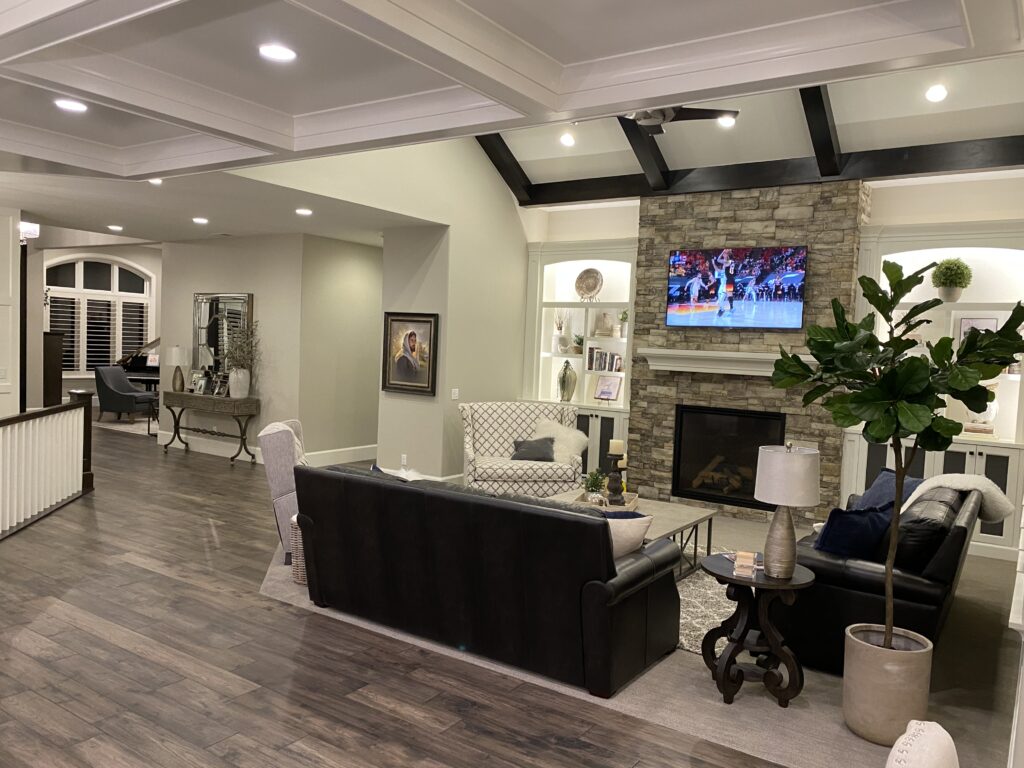 Modern living room with stone fireplace, TV, and stylish furniture.