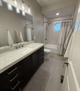 Modern bathroom remodel in a Herriman, Utah home featuring a double vanity, quartz countertop, and tiled tub shower